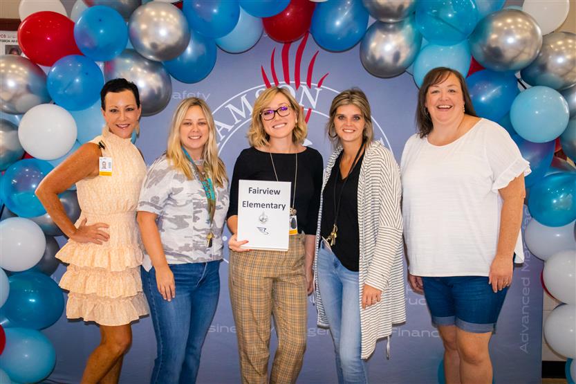 A group of teachers smile